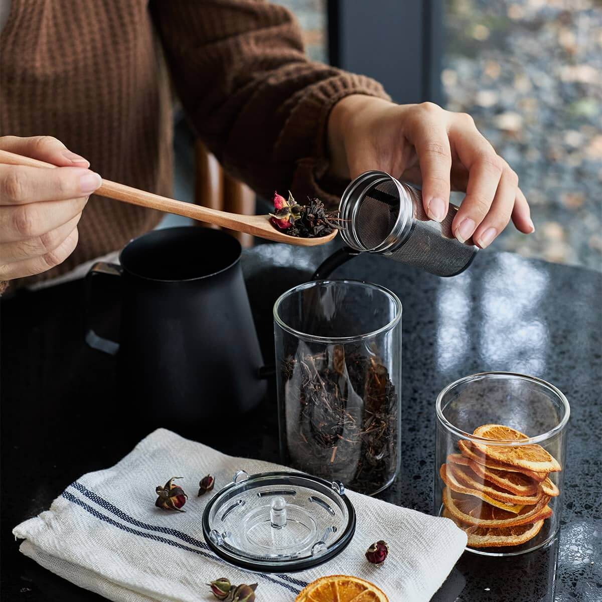 Sttoke Tea Infuser used to prepare fresh tea with a cup on the table, showcasing ceramic interior and stainless mesh.
