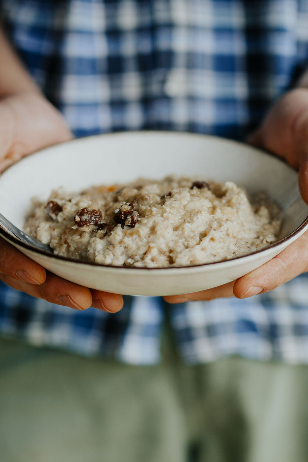Person holding a bowl of Back Country Cuisine Porridge Supreme with dried fruit