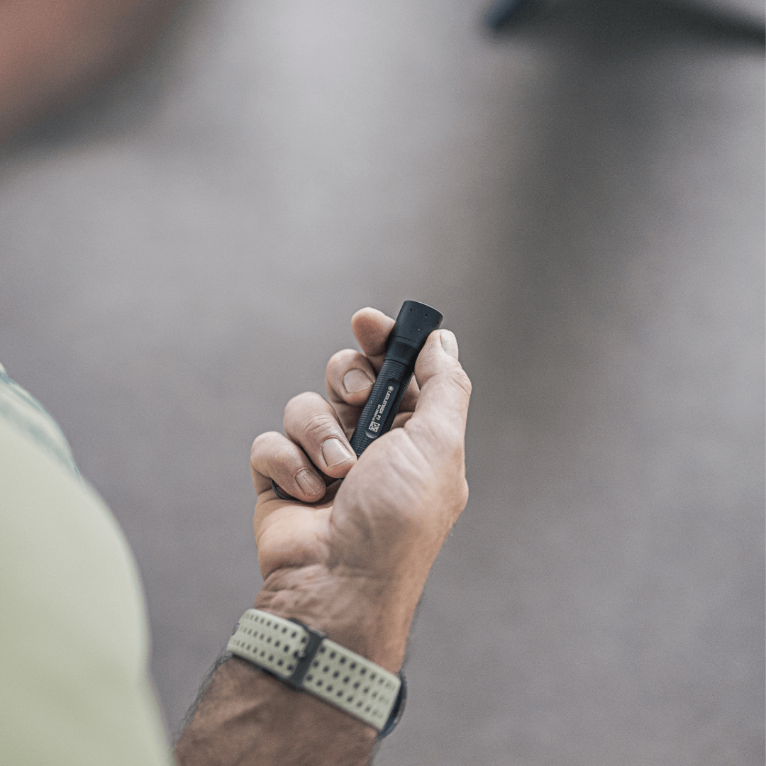 P3 tiny key flashlight held in hand, showcasing its compact design and focusable beam.