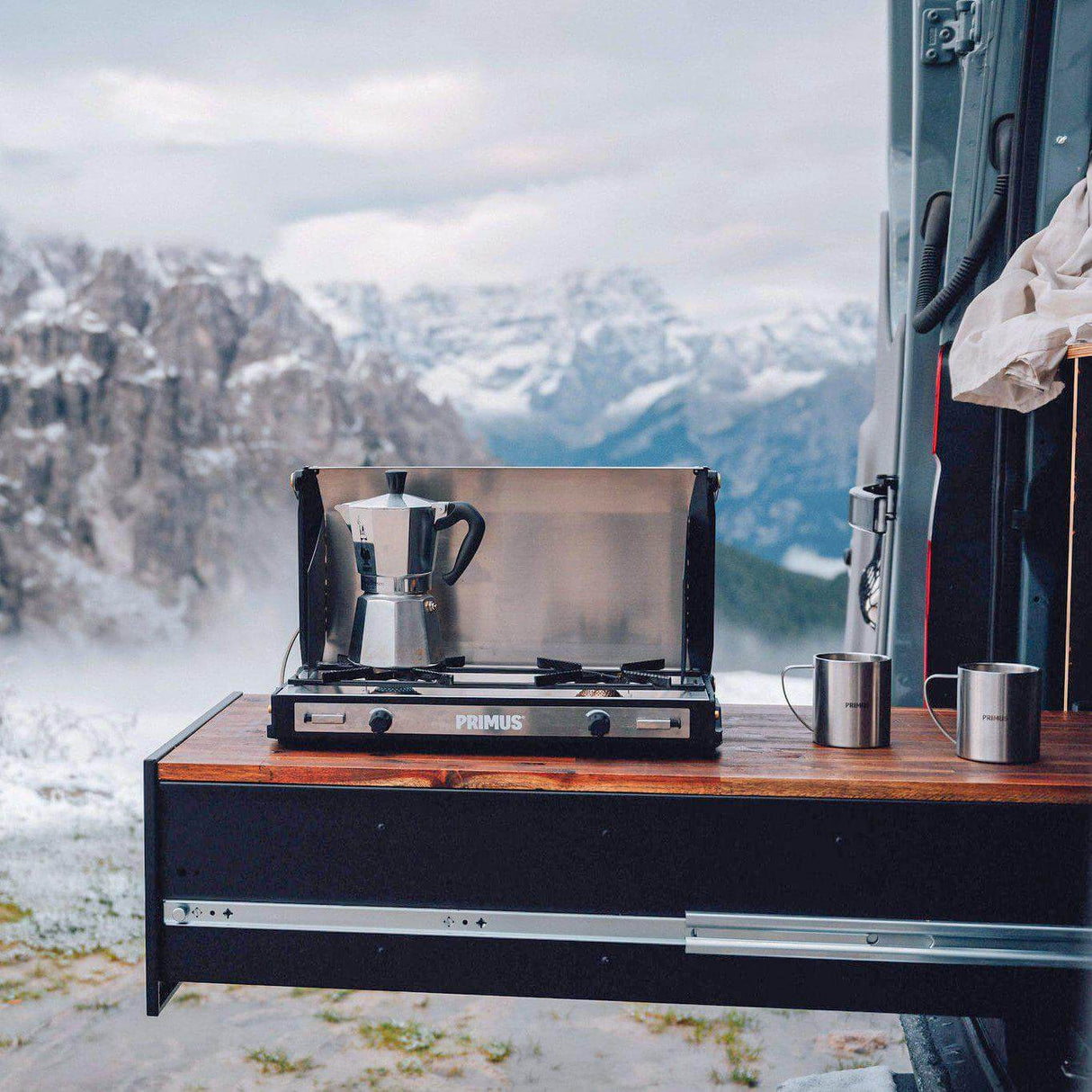 Primus Tupike Stove II set up for cooking with stunning mountain view in background, showcasing outdoor usability and design.