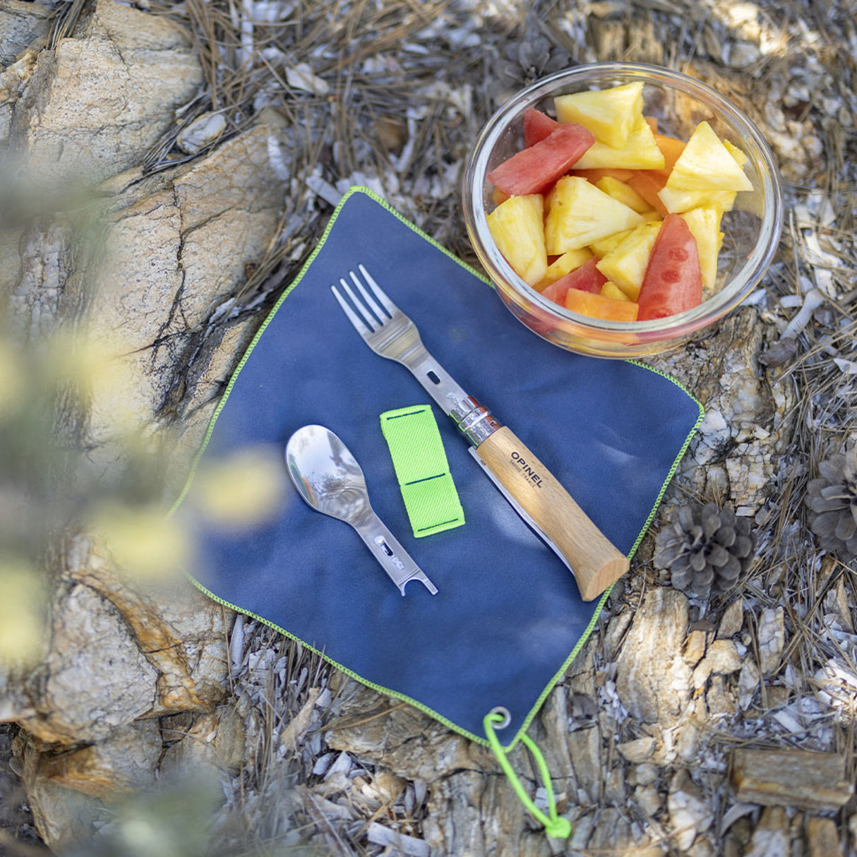 Opinel Complete Picnic + Set with folding knife, fork, and spoon on a mat, ideal for outdoor dining or camping meals, showcasing Opinel brand.