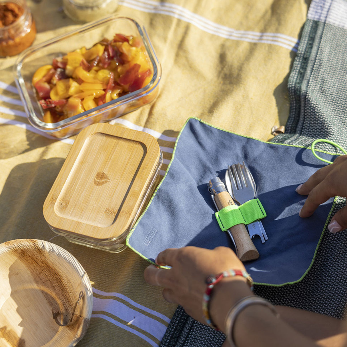 Opinel Complete Picnic + Set displayed in a charming picnic scene, showcasing sustainable and reusable dining accessories for outdoor meals.