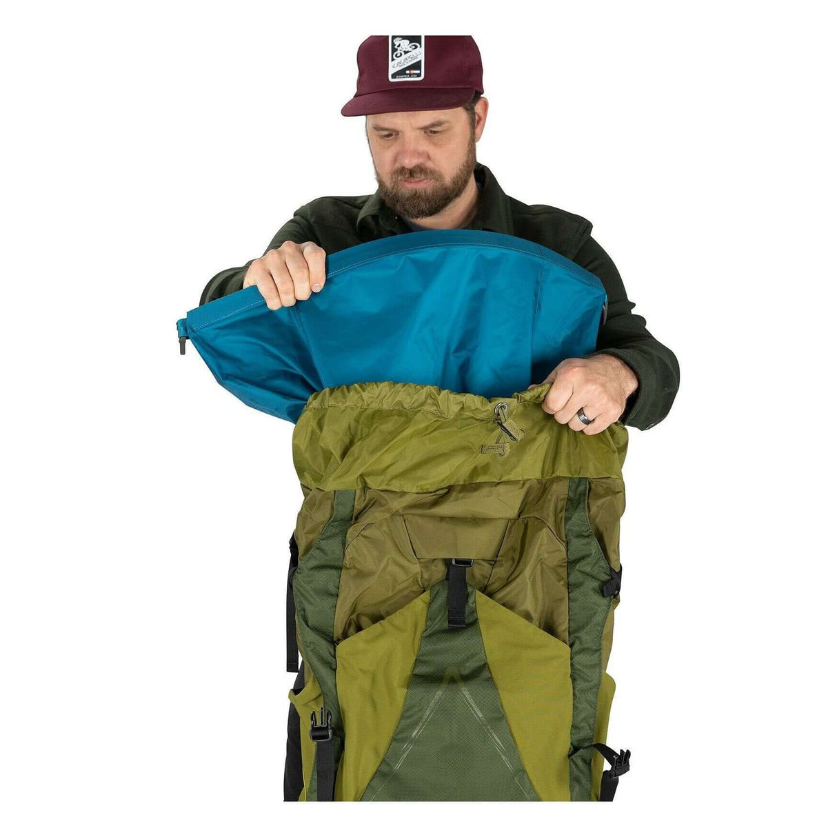 Man opening an ultralight pack liner medium inside a backpack, featuring a waterproof design for weather protection.
