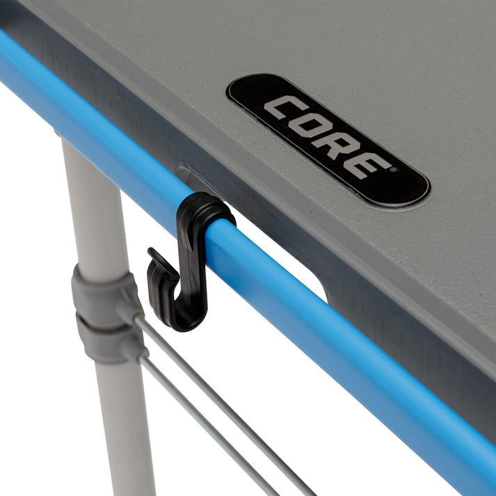 Core Equipment 4 Foot Outdoor Table with FlexRail — accessories organized along the rail during outdoor cooking.