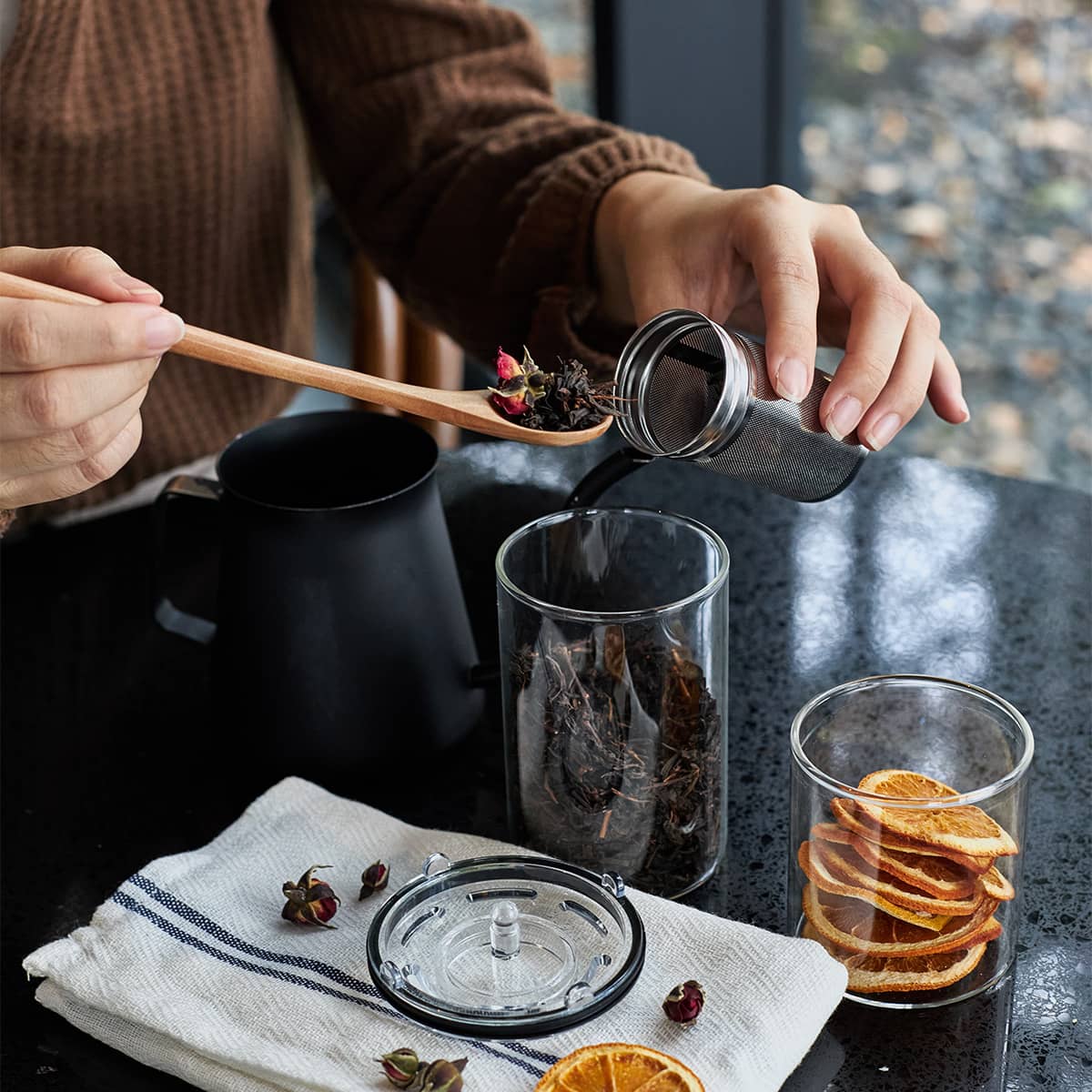 Sttoke Tea Infuser used to prepare fresh tea with a cup on the table, showcasing ceramic interior and stainless mesh.