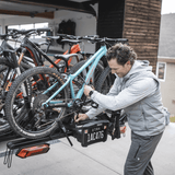 User installing Thule Verse add-on - 2 Bike to expand bike carrying capacity on a Thule platform hitch rack for 2-inch receivers.