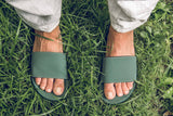 Feet wearing Indosole Slides recycled tire sole sandals on grass