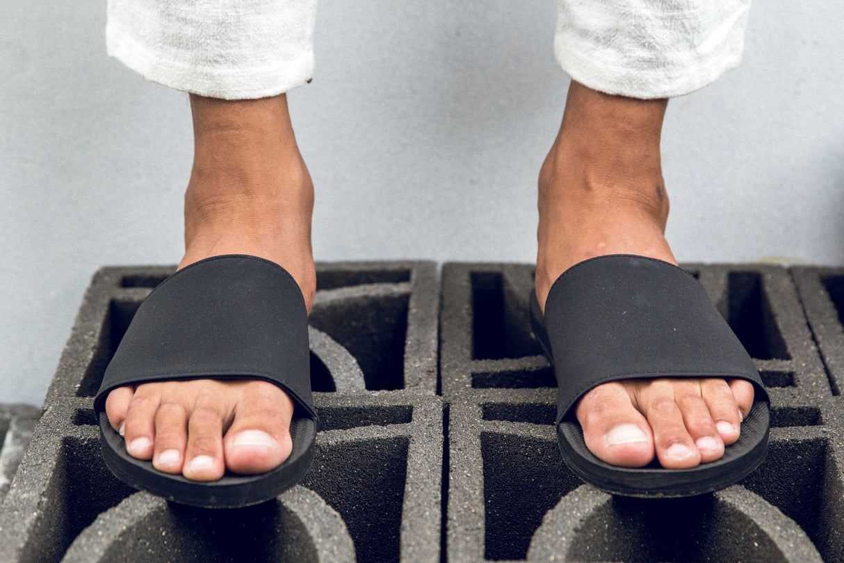 Person wearing Indosole Slides recycled tire sole sandals for men, showcasing eco-friendly and comfortable footwear.