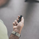 P3 tiny key flashlight held in hand, showcasing its compact design and focusable beam.