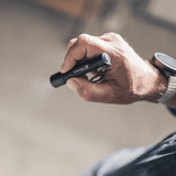 P3 tiny key flashlight held in hand showing focusable beam and sleek design.