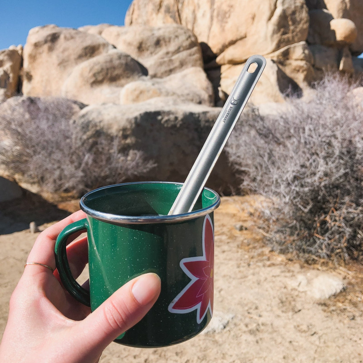 Camping scene with SilverAnt Long Handle Titanium Spoon in metallic mug, perfect for outdoor adventures and ultralight backpacking
