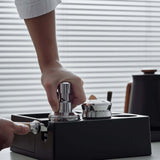 Person using the Muvna Titan Distributor 58mm coffee leveler for consistent coffee extraction.