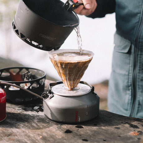 Primus LiTech Coffee and Tea Kettle pouring hot water over coffee filter outdoors.