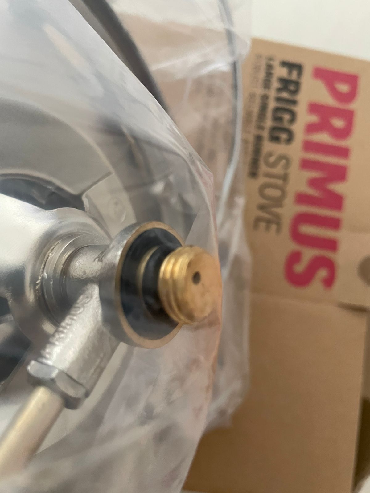 Close-up of Primus Frigg Stove component with packaging box visible in the background.